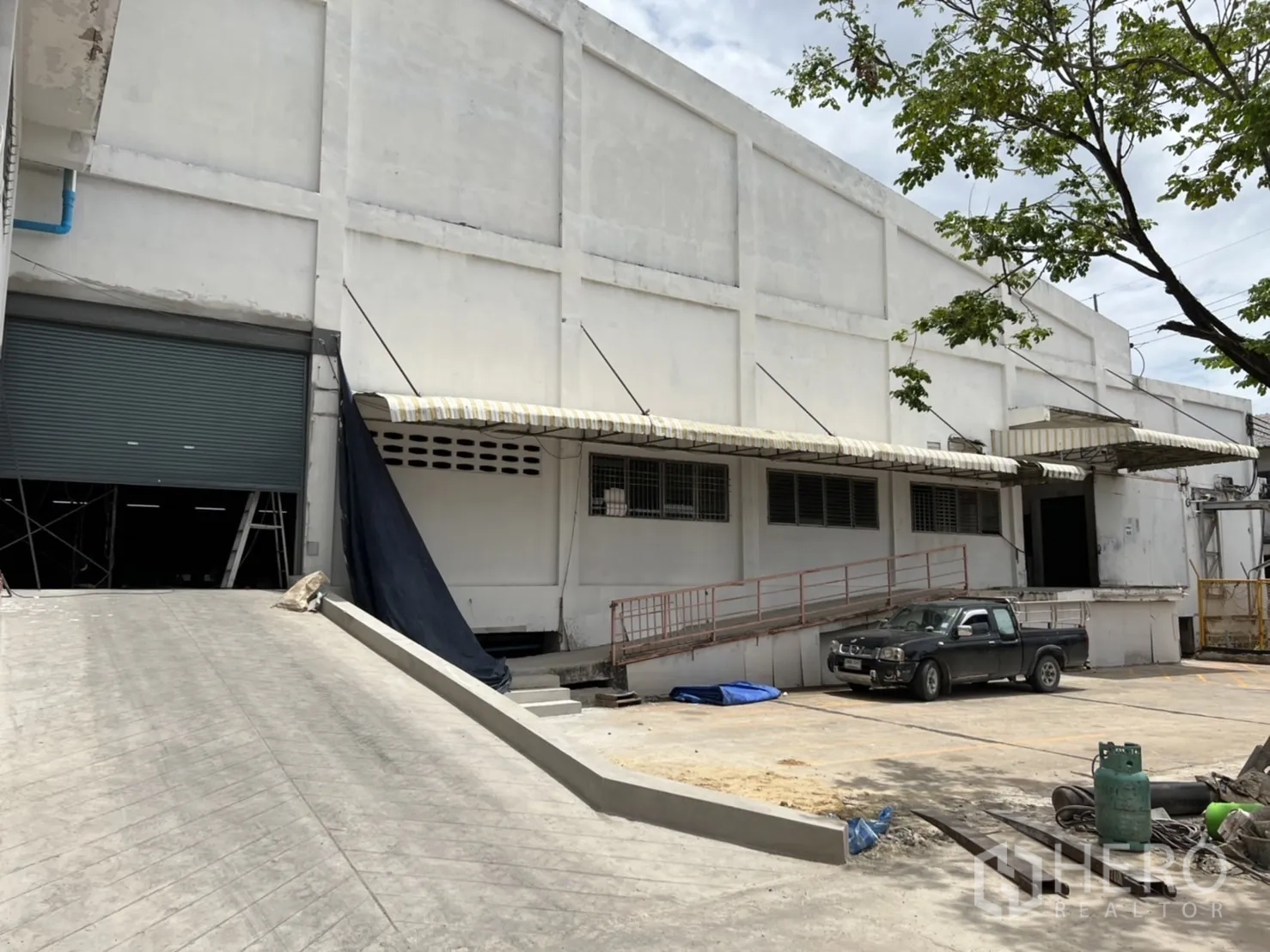 Factory for rent in Phra Samut Chedi, Samut Prakan - Factory exterior with dock‑high loading bays, roll‑up doors and a truck ramp.