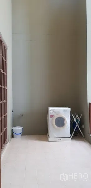 Condominium for rent in Khlong Toei, Bangkok - Covered utility balcony with washing machine and drying rack.