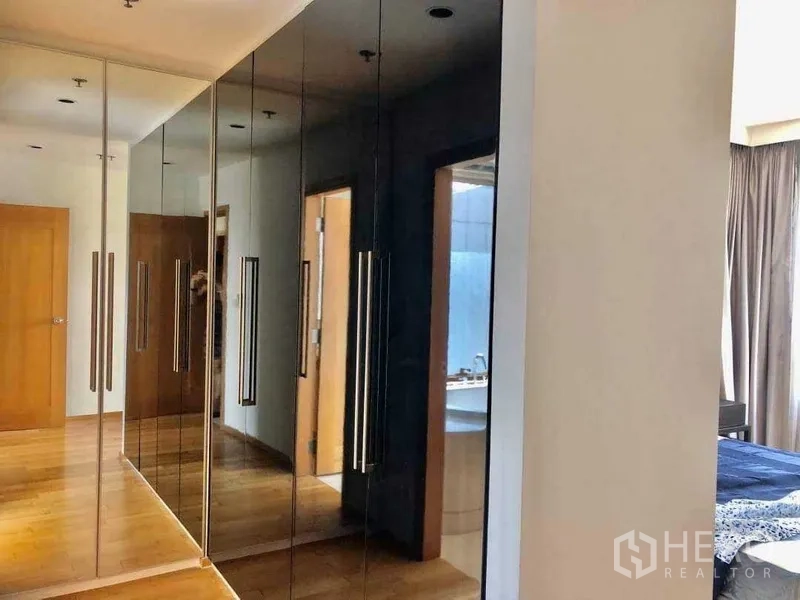 Condominium for sale in Khlong Toei, Bangkok - Mirrored and black wardrobes in the bedroom corridor beside the bathroom.