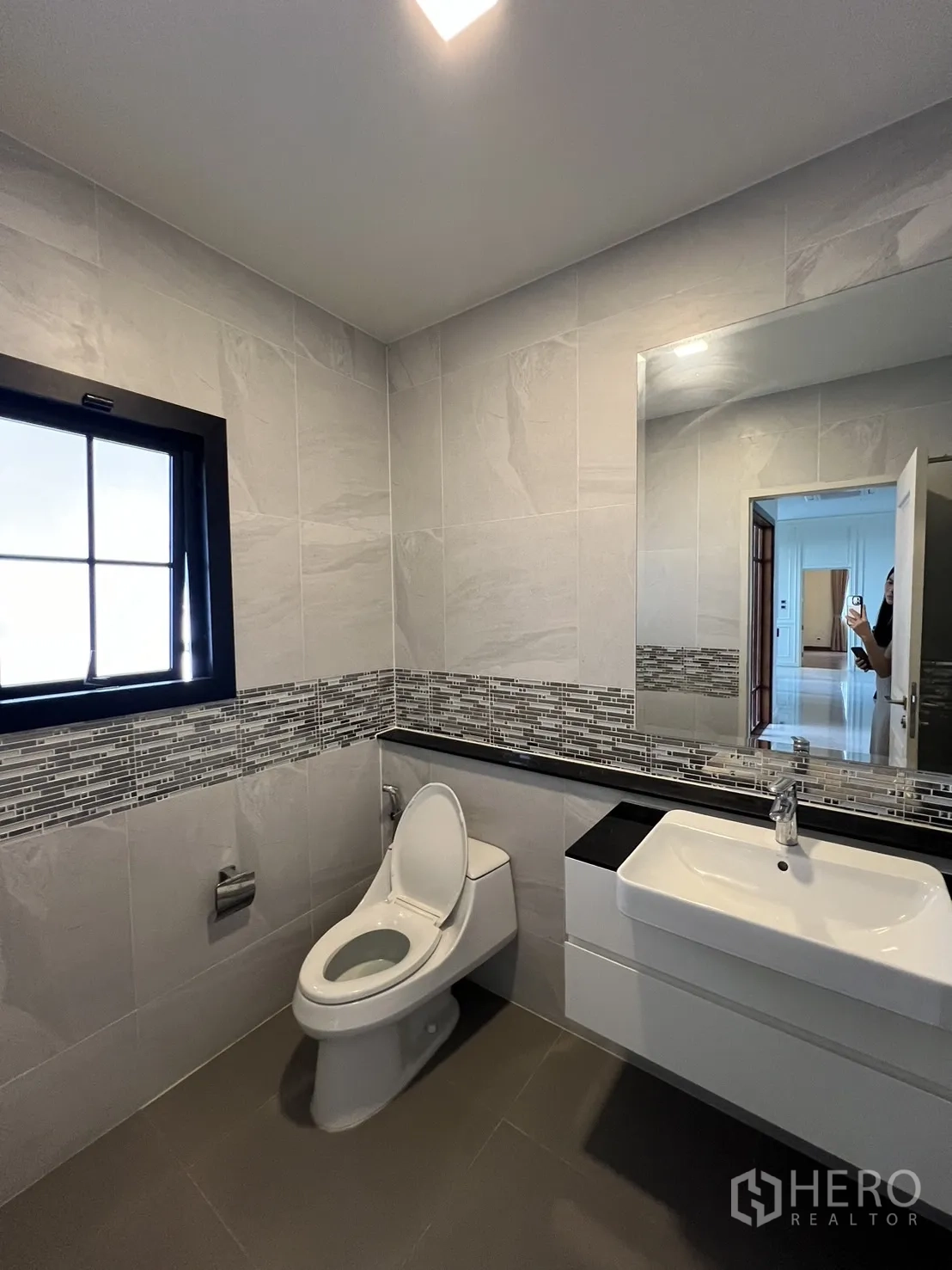 Detached House for rent or sale in Prawet, Bangkok - Guest bathroom with tiled walls, vanity and window.