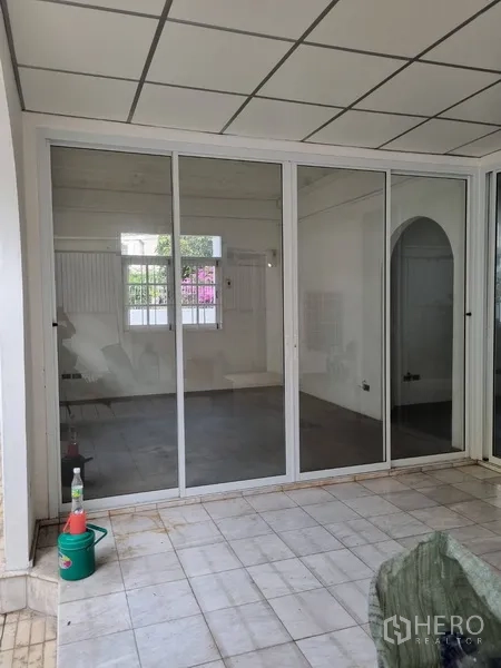 Detached House for rent or sale in Sathon, Bangkok - Close-up of tiled patio with wide sliding doors connecting indoor and outdoor areas.