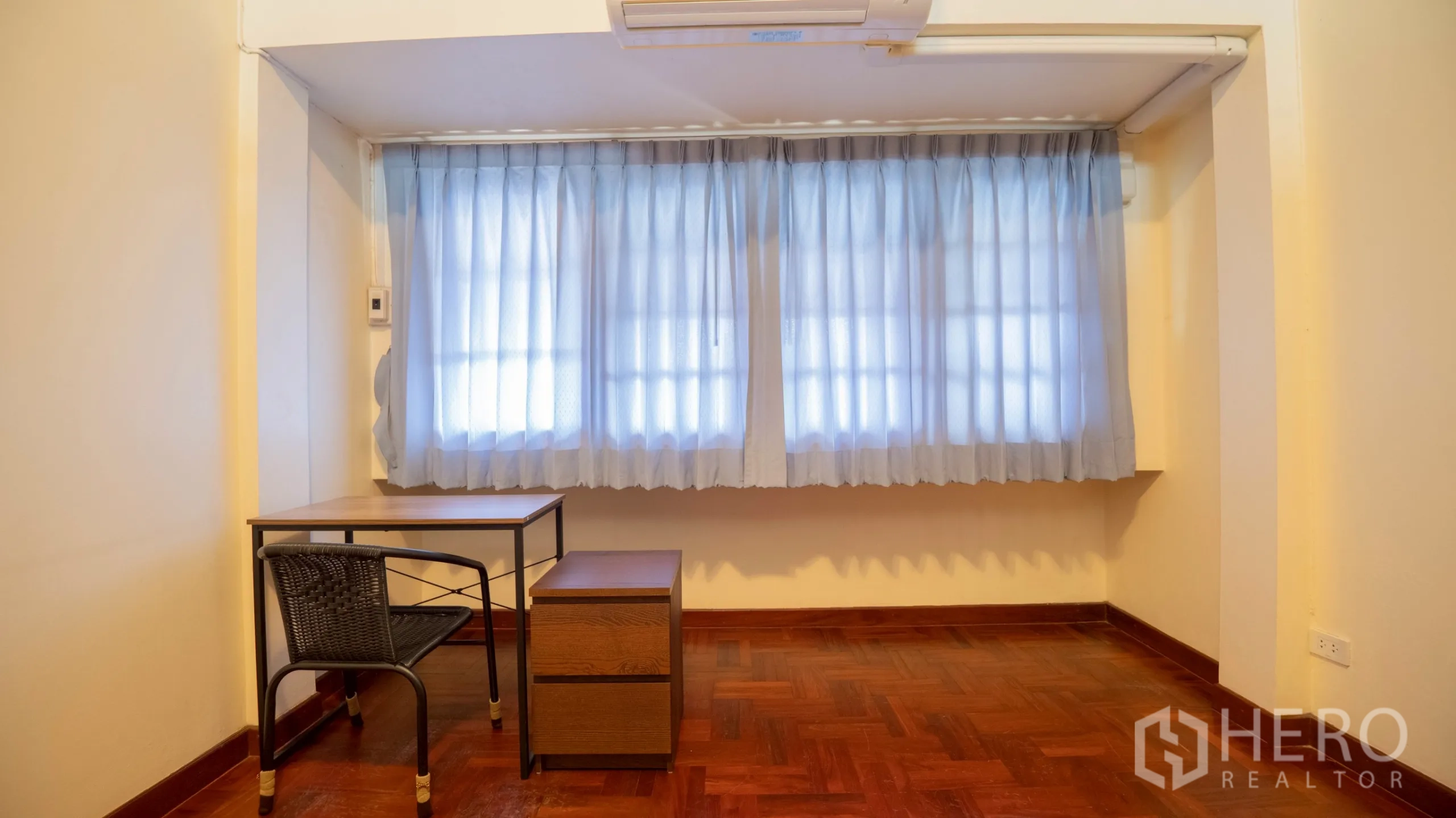 Townhouse for rent in Khlong Toei, Bangkok - Small study nook with desk, chair and window dressed with blue sheer curtains.