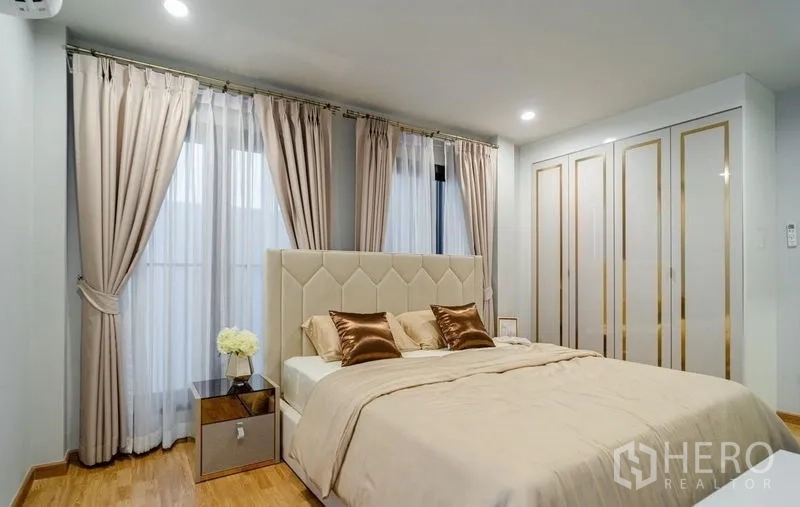 Detached House for sale in Lam Luk Ka, Pathum Thani - Primary bedroom with large wardrobe and soft lighting.