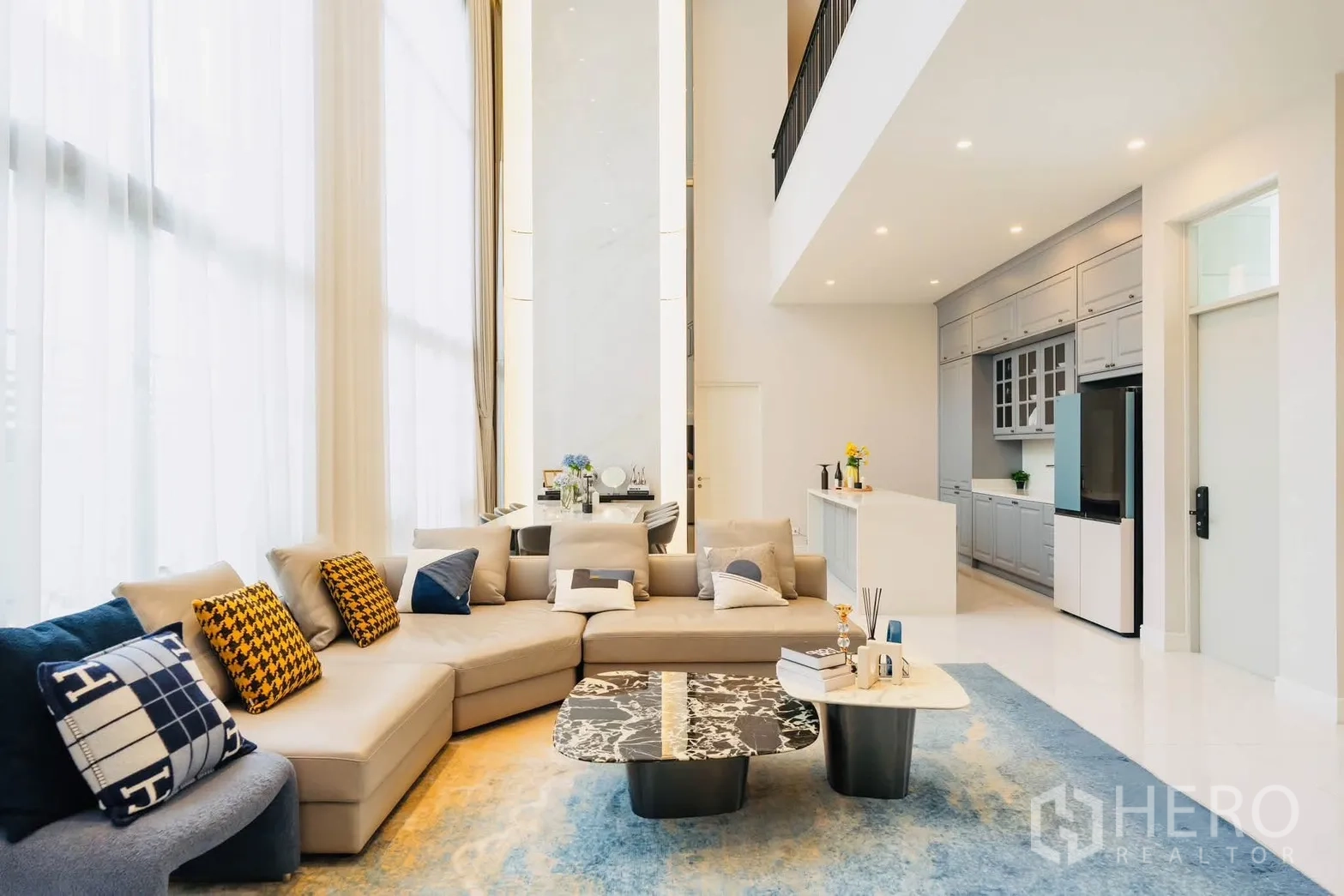 บ้านเดี่ยว for rent or sale in Bang Kapi, Bangkok - พื้นที่นั่งเล่นเปิดโล่งพร้อมโซฟาเข้ามุม โต๊ะกลางหินอ่อน และครัวติดกัน