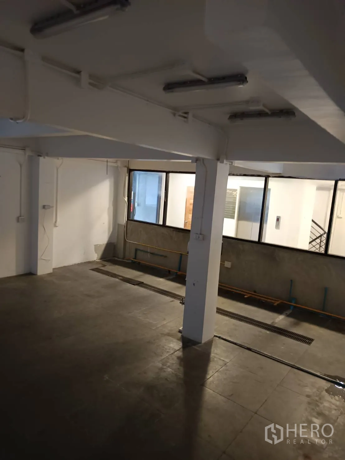 Retail Space for rent in Watthana, Bangkok - Storage or prep area with drainage channel, support column and overhead lighting.