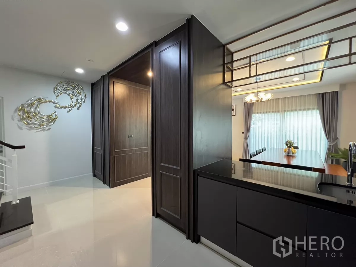 Detached House for rent or sale in Bang Kapi, Bangkok - Entrance hall beside kitchen with decorative wall art and mirror detail.