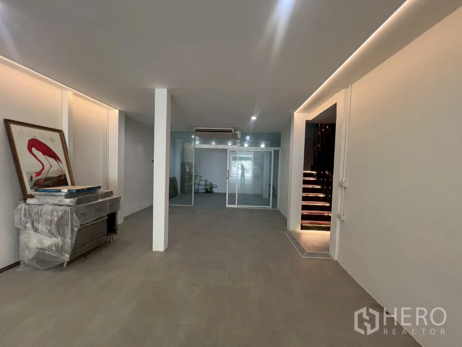 โฮมออฟฟิศ for rent in Watthana, Bangkok - พื้นที่ทำงานเปิดโล่ง มีห้องกั้นกระจกด้านหลังและบันไดไม้มีไฟ