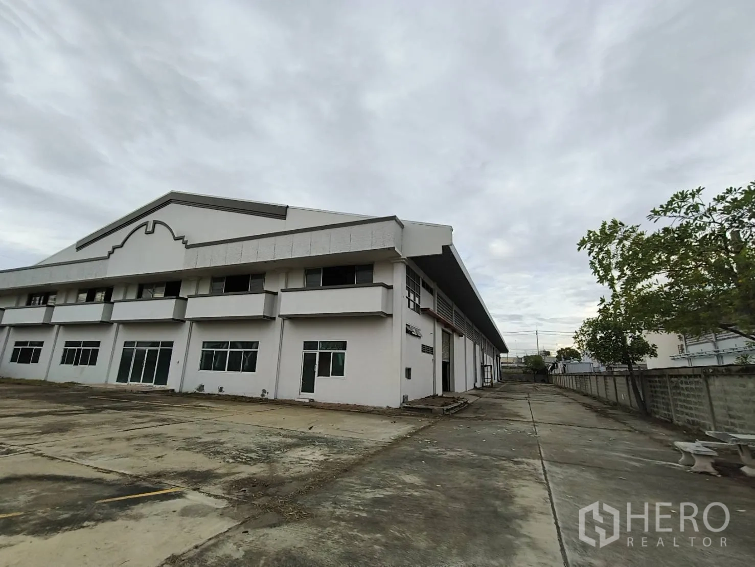 โกดัง for rent in Phra Nakhon Si Ayutthaya, Phra Nakhon Si Ayutthaya - ด้านข้างอาคารโกดังพร้อมลานคอนกรีต หน้าต่าง และทางรถวิ่งยาว