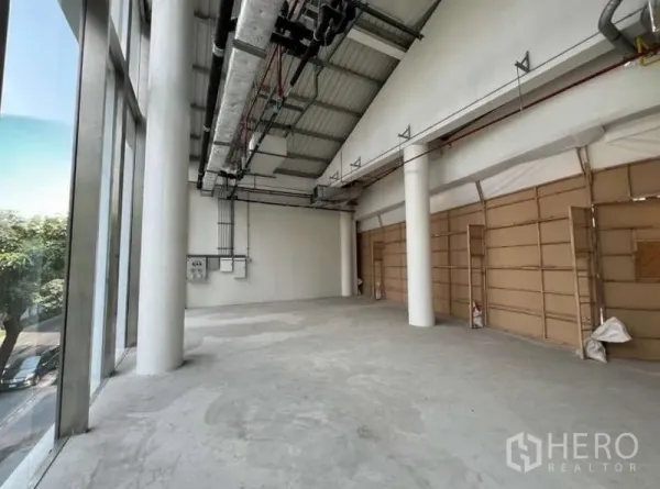 Retail Space for rent in Phaya Thai, Bangkok - Long open retail space with high ceiling, glass wall to the street, service panels and temporary boarded partitions.