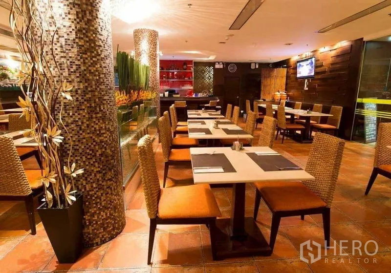 Retail Space for rent in Khlong Toei, Bangkok - Warm-lit dining area with mosaic columns, wicker chairs and tiled flooring.