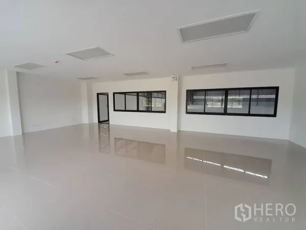 Factory for rent in Mueang Rayong, Rayong - Bright internal office space with tiled flooring, ceiling panels, and black-framed windows.