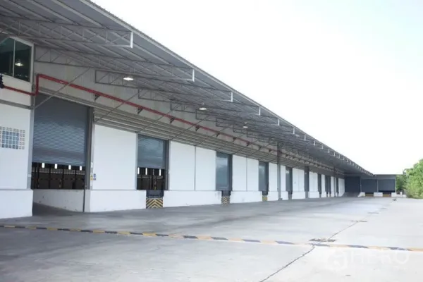 Warehouse for rent in Si Racha, Chon Buri - Raised loading bays in a row with canopy lighting, roller shutters and a wide truck maneuvering area.