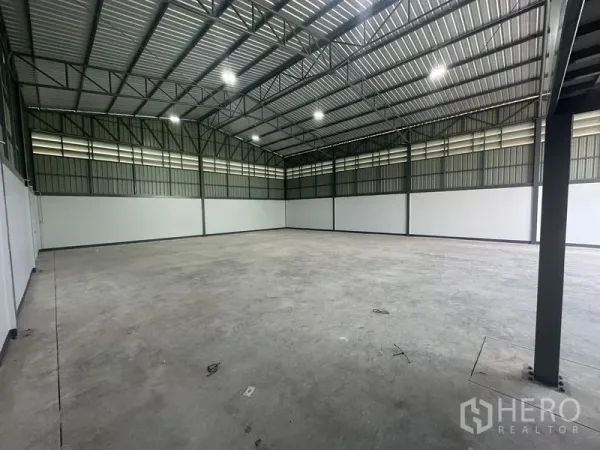 Warehouse for rent in Khlong Toei, Bangkok - Wide, high-clear warehouse interior with steel truss roof, LED lighting, and smooth concrete floor.