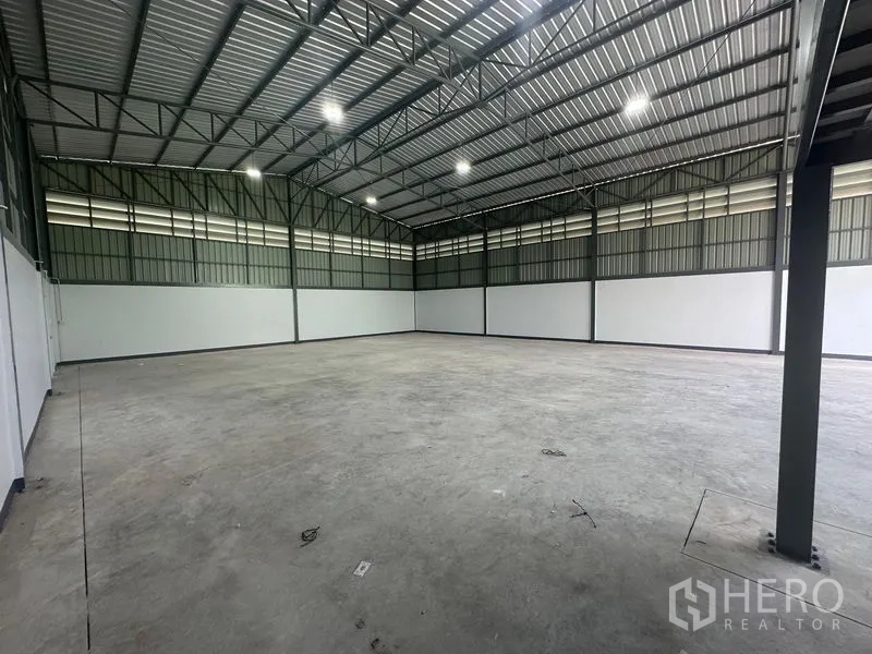 Warehouse for rent in Khlong Toei, Bangkok - Wide, high-clear warehouse interior with steel truss roof, LED lighting, and smooth concrete floor.