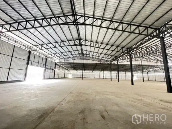 Factory for rent in Mueang Samut Sakhon, Samut Sakhon - Clear-span warehouse interior with steel truss roof and smooth concrete floor.