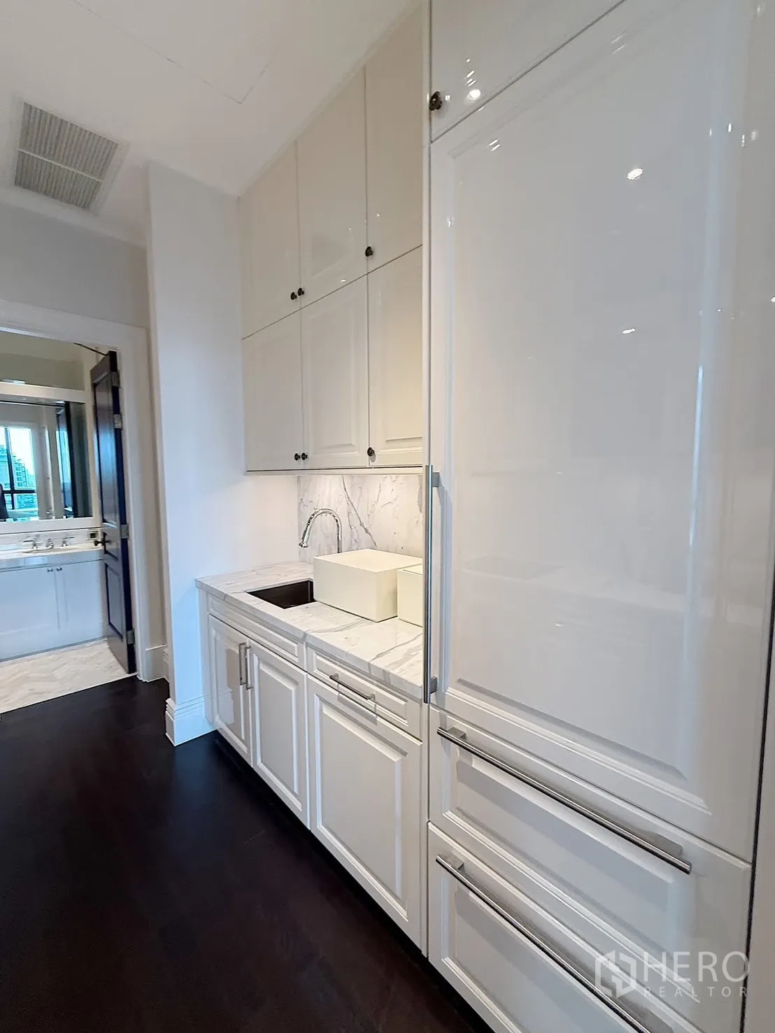 Condominium for rent or sale in Pathum Wan, Bangkok - Opposite side of the kitchen with an integrated refrigerator, secondary sink, and ample storage.