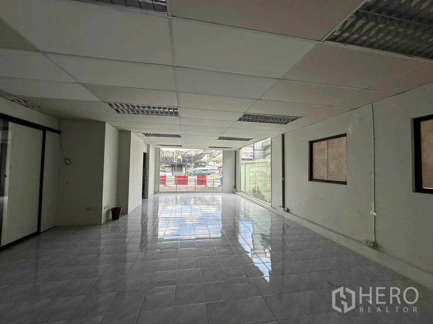 Warehouse for rent in Suan Luang, Bangkok - Open plan showroom with suspended ceiling lighting and full-height front glazing.