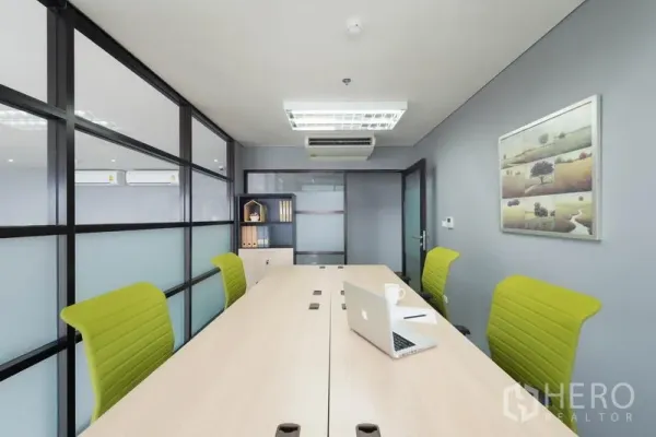 Office Space for rent in Chatuchak, Bangkok - Glass-partition meeting room with long conference table, lime green chairs, and ceiling air conditioning in a modern Ladprao office for rent.