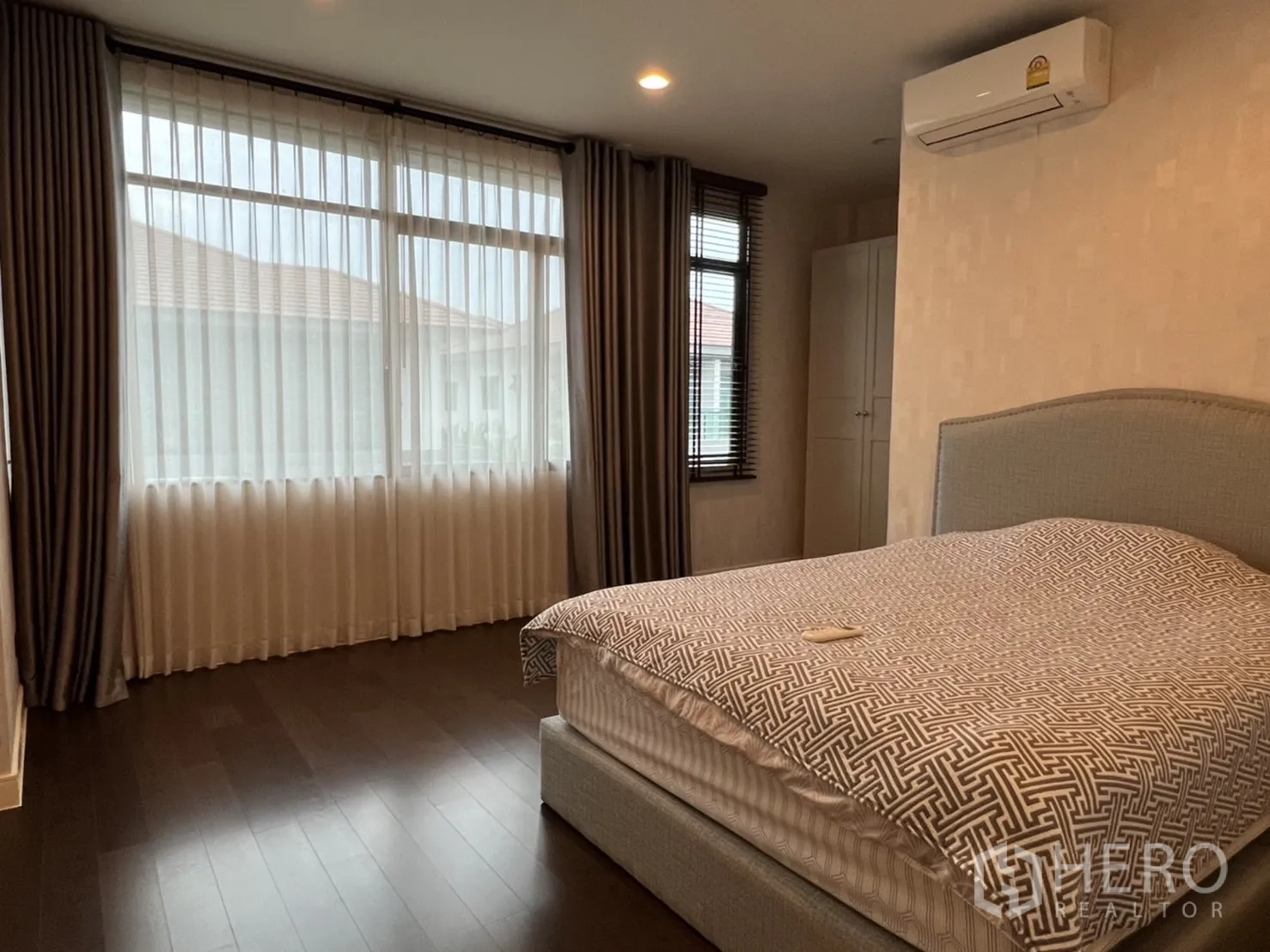 Detached House for rent or sale in Bang Kapi, Bangkok - Secondary bedroom with large window, layered curtains and an upholstered bed.