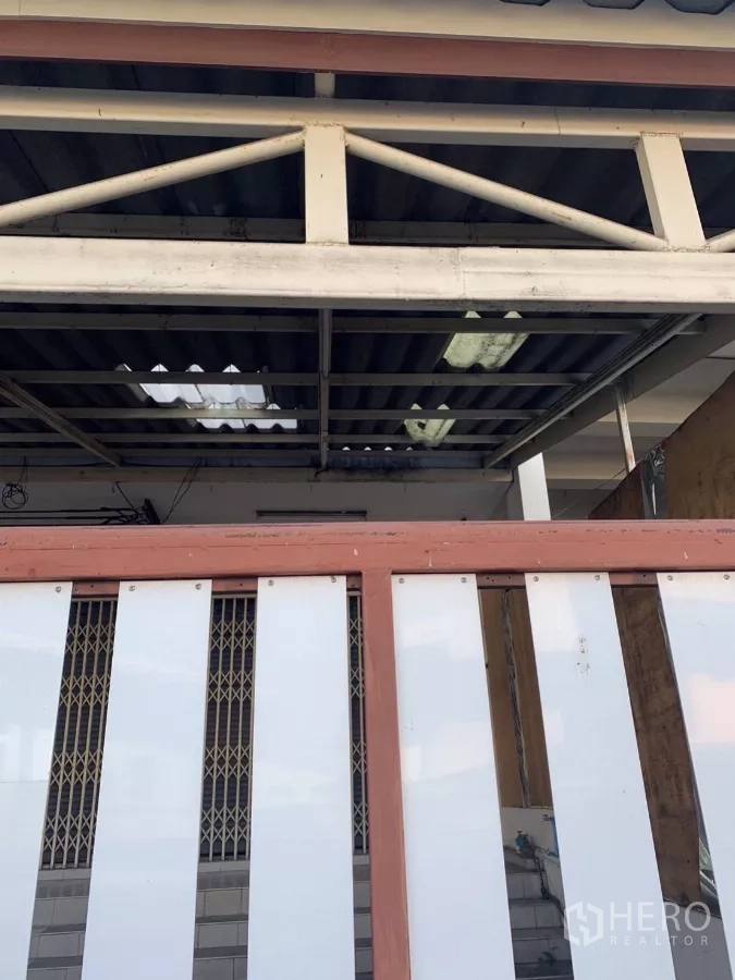 Shophouse for rent in Suan Luang, Bangkok - Covered front area with steel truss roof and sliding gate details.
