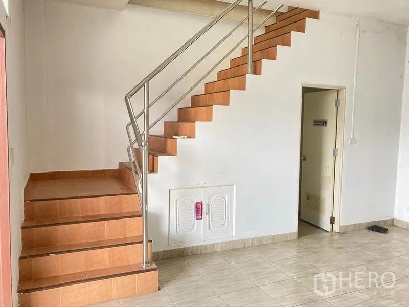 Warehouse for rent in Bang Phli, Samut Prakan - Tiled office area with wooden staircase and a doorway to the restroom inside the warehouse.
