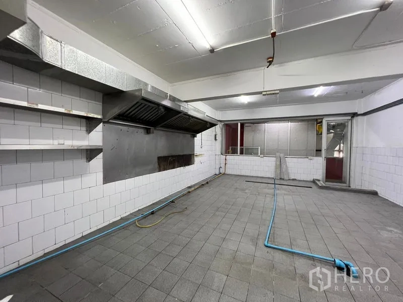 Shophouse for rent - Wide view of commercial kitchen with twin exhaust hoods and tiled walls.