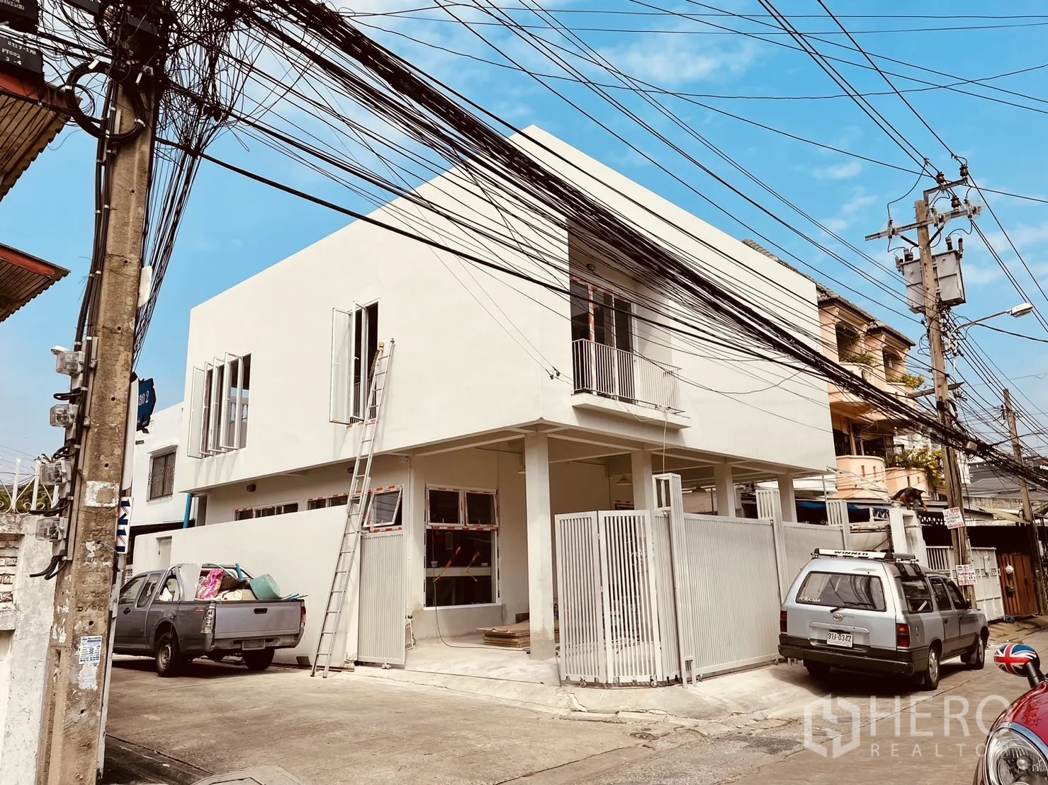 Detached House for rent or sale in Din Daeng, Bangkok - Modern two-storey corner detached house with white facade, gated parking and ladder near MRT Sutthisan.
