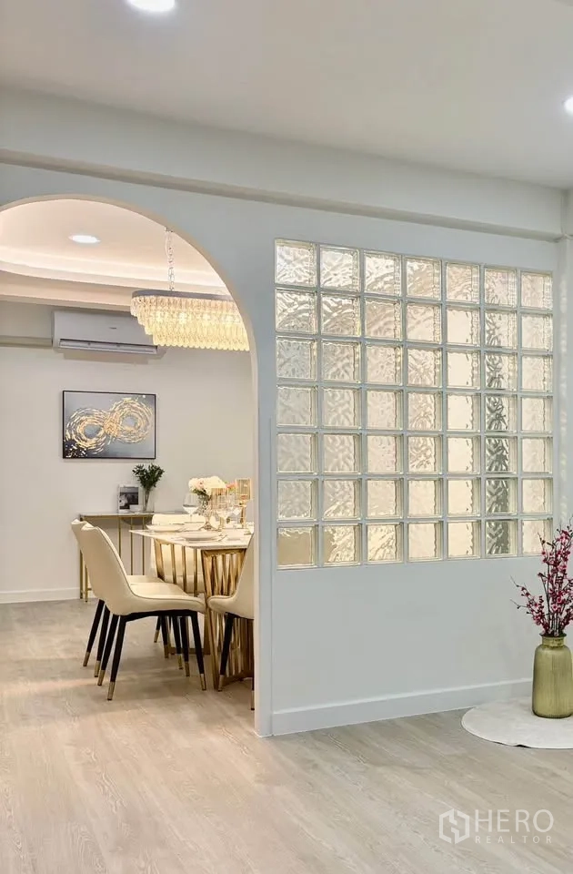 Detached House for rent in Huai Khwang, Bangkok - Dining area with arched opening and glass-block partition beside light flooring.