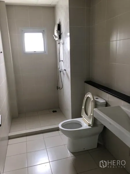 Home Office for rent in Wang Thonglang, Bangkok - Tiled bathroom with separate shower area, toilet, sink, and a small window.