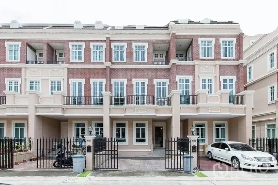 Townhouse for rent in Watthana, Bangkok - Three-storey townhouse facade in Watthana, Bangkok with brick accents, balconies and gated parking near BTS On Nut.
