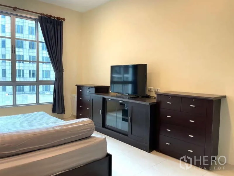 Apartment for rent in Khlong Toei, Bangkok - Master bedroom TV console and drawer units facing a large window.