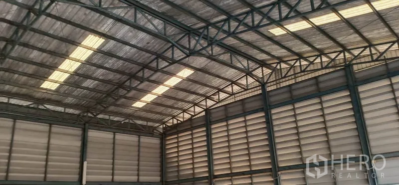 Warehouse for rent in Khlong Luang, Pathum Thani - High-clearance steel frame and ventilated wall panels inside the warehouse loading area.