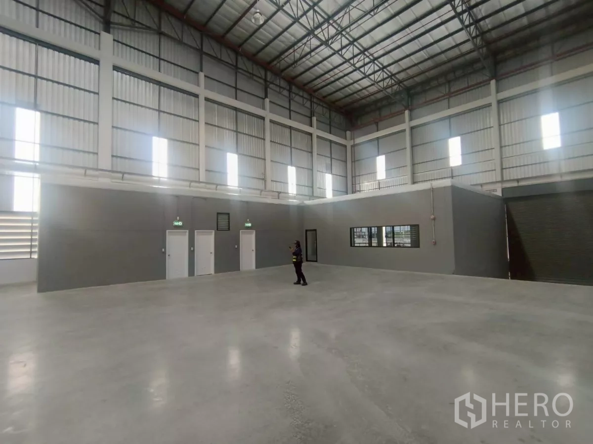 Factory for rent in Si Racha, Chon Buri - Internal block with service doors and a roller shutter inside the manufacturing area.
