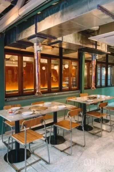 Detached House for sale in Khlong Toei, Bangkok - Indoor dining hall with marble-top tables, wooden chairs and exposed metal ventilation ducts.