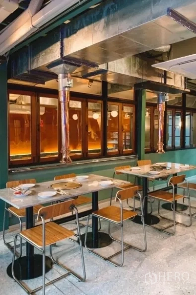 Detached House for sale in Khlong Toei, Bangkok - Indoor dining hall with marble-top tables, wooden chairs and exposed metal ventilation ducts.
