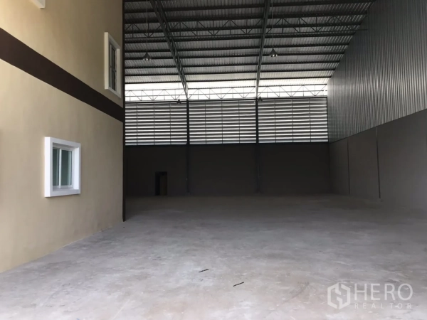 Factory for rent or sale in Mueang Samut Sakhon, Samut Sakhon - Spacious warehouse interior with high steel roof, louvered ventilation and smooth concrete floor.