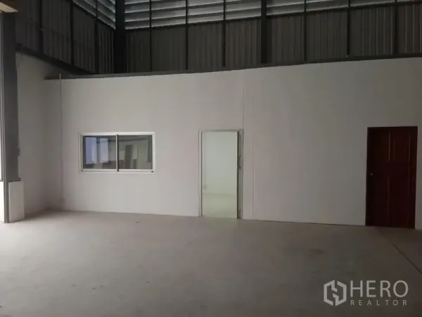 货栈 出租在Suan Luang, Bangkok - 仓库内墙设玻璃窗与推拉门，通往明亮的办公室。