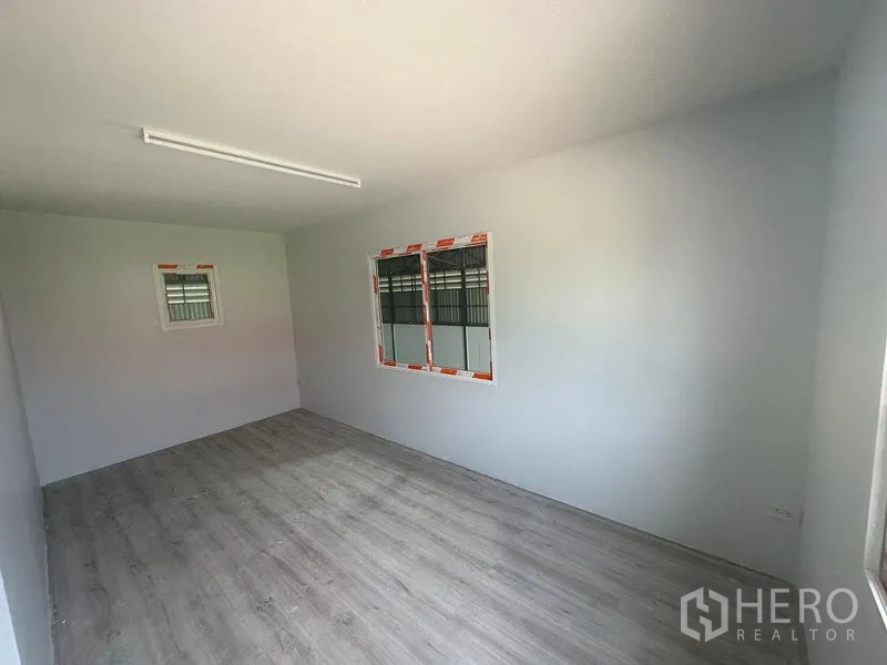 Warehouse for rent in Khlong Toei, Bangkok - Spacious office room with vinyl flooring, white walls, and windows.
