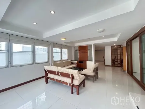 Detached House for rent in Suan Luang, Bangkok - Bright living room with large windows and a cream sofa set.