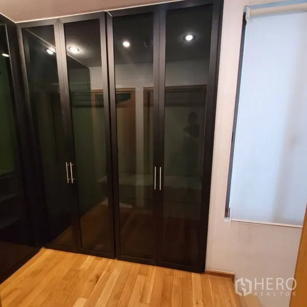 Condominium for rent in Khlong Toei, Bangkok - Built-in black glass wardrobes providing ample storage.