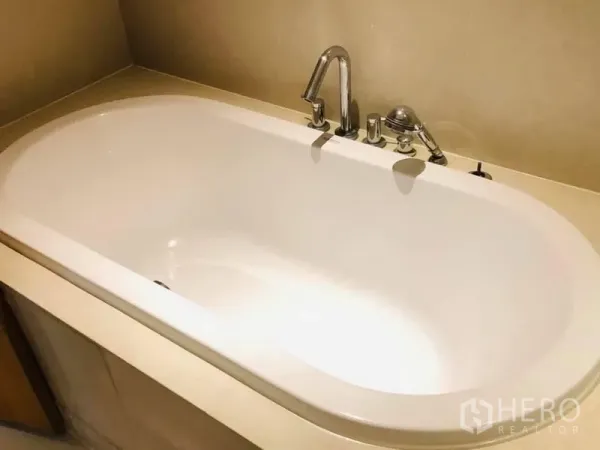 Condominium for rent in Khlong Toei, Bangkok - Modern white bathtub with chrome fixtures in a contemporary Khlong Toei, Bangkok condominium.