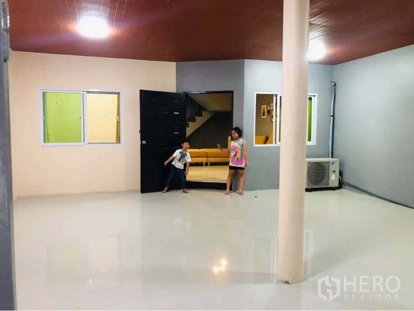 Townhouse for rent or sale in Huai Khwang, Bangkok - Expansive covered front terrace with pillar and access to the living room.