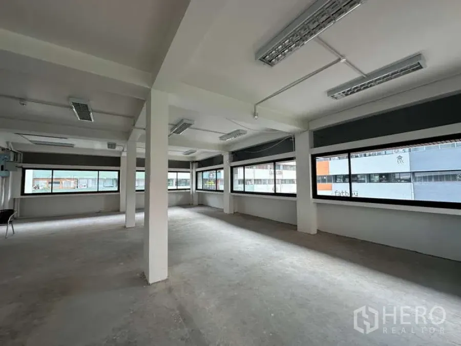 Office Space for rent in Watthana, Bangkok - Corner office area with panoramic windows and exposed ceiling lighting for flexible layouts.