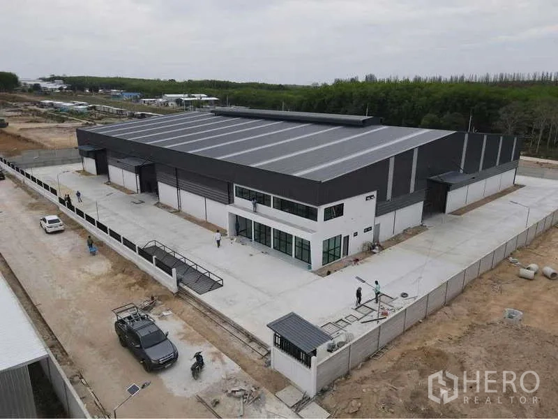 Warehouse for rent or sale in Nikhom Phatthana, Rayong - Aerial view of the warehouse complex with front office, perimeter fencing and ample truck turning area.