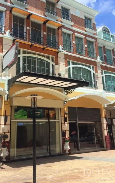 Home Office for rent or sale in Sathon, Bangkok - European-style multi-storey home office facade in Sathon with glass shopfront, canopy and roller shutter under blue sky.