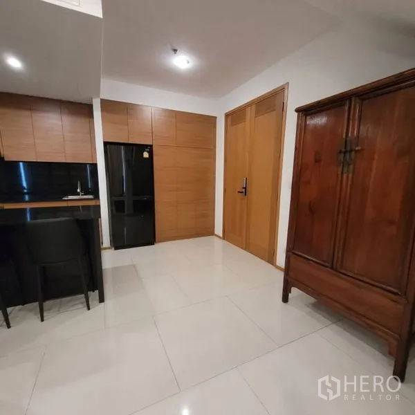 Condominium for rent in Khlong Toei, Bangkok - Entry area beside the kitchen with built-in cabinets and refrigerator.