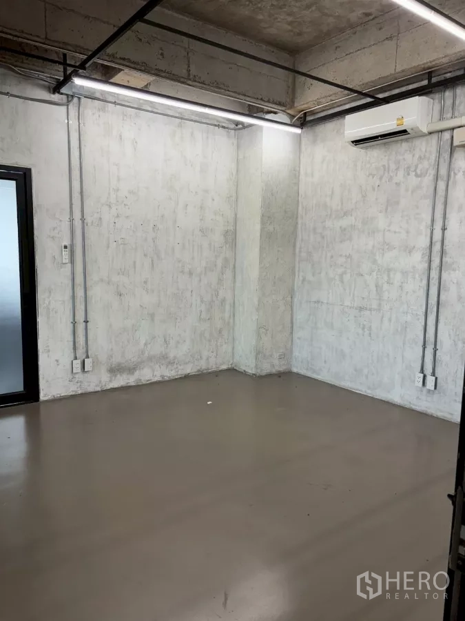 办公空间 出租在Watthana, Bangkok - 小型封闭房间，水泥墙、线性LED灯与壁挂式空调。