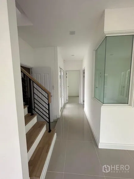 Detached House for rent - Hallway with wooden staircase, metal railing, and corner glass feature.