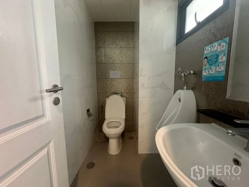 Home Office for rent in Suan Luang, Bangkok - Spacious low-ceiling office area with wood floors and frosted divider.