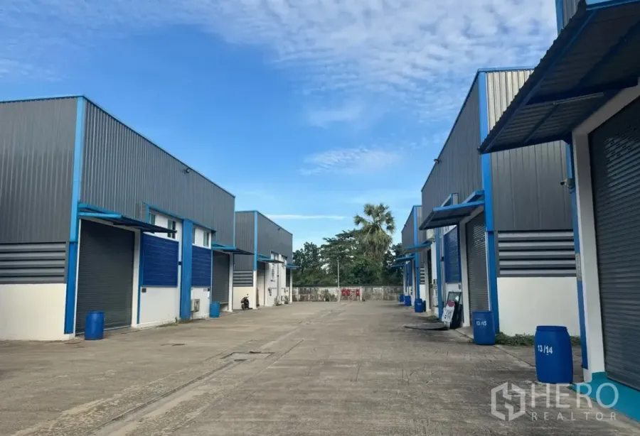 Warehouse for rent in Lam Luk Ka, Pathum Thani - Exterior view of a warehouse compound with multiple units and a wide driveway.
